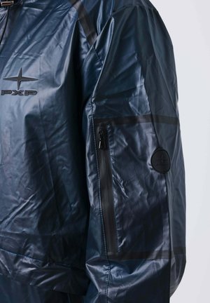 Donkerblauwe waterdichte jas met een zwarte ritszak op de mouw en een zwart logo-opdruk, waarmee de details van de bovenste torso en arm worden getoond.