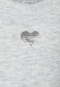 Grauer Strickpullover mit weicher Textur, der eine herzförmige Applikation aus silbernen Pailletten auf der Vorderseite hat. Markenetikett am Halsabschluss sichtbar.