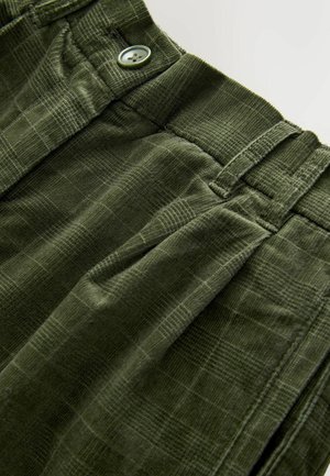 Olijfgroene corduroy broek met een gestructureerd ruitpatroon, voorzien van een knoopsluiting en plooien. Accenten zijn een gestikte tailleband en zijzakken.