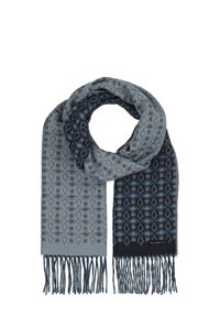 Écharpe tissée avec un motif géométrique dans des nuances de bleu, avec des bords frangés et une étiquette. Tissu texturé et doux.