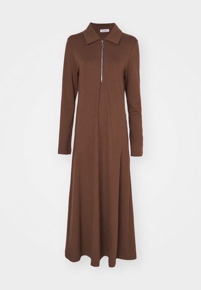 Pruun pikkade varrukatega kleit, millel on struktuurne krae ja eesmine tõmblukk. Valmistatud siledast kangast, omab lõdvaks sobivat lõiget ja voolavat seelikut.