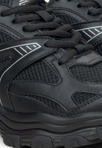 Černé sportovní boty s síťovaným designem, texturovanými koženými akcenty, silnou gumovou podešví a reflexními detaily po stranách.