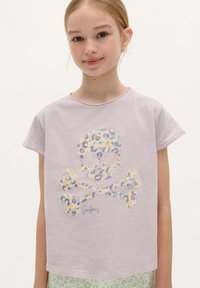 Lila katoen t-shirt met een multikleurig leopardenprint doodskop en gekruiste beenderen ontwerp. Korte mouwen en een ronde hals.