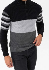 Knitted pullover with a high collar, featuring horizontal stripes in black, gray, and light gray, textured design, and ribbed cuffs and hem.