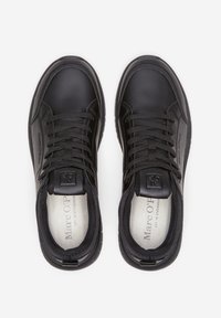 Sneakers nere in pelle con punta arrotondata, lacci testurizzati, colletto imbottito e soletta brandizzata con fodera interna liscia.