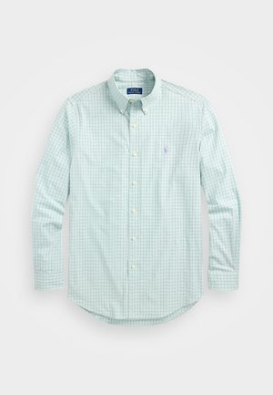 Camisa de botón verde claro con un patrón de cuadrícula en verde más oscuro, que presenta un cuello clásico, mangas largas y un pequeño logotipo bordado.