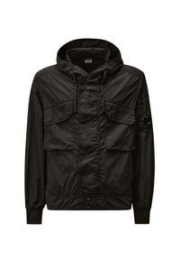 Giacca nera leggera con Cappuccio, dotata di due tasche frontali, chiusura con zip e polsini elasticizzati. Realizzata in tessuto texturizzato con finitura opaca.