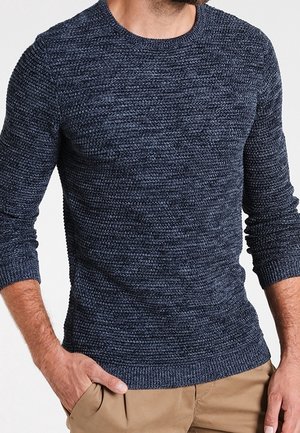 Pull en maille bleu marine avec un motif texturé, col rond, et poignets et ourlet côtelés. Le matériau semble doux et légèrement épais.