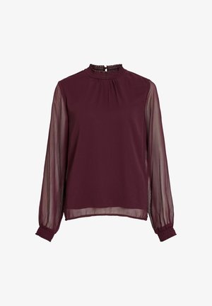 Blusa bordeaux con un alto scollo arricciato, maniche lunghe trasparenti e polsini arricciati; tessuto morbido con una superficie liscia.
