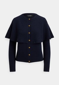 Tumesinis sinises kardiganis soonilise tekstuuriga, millel on kihiline keep-muster, kuldsed nööbid ja soonikkoes varrukate mansetid, mis on keha järgi lõigatud.