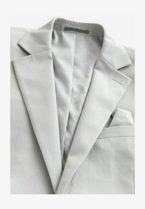 Hellgrauer Blazer mit strukturierter Webart, mit Reverskragen, einem Taschenquadrat und einem gemusterten Futter. Besitzt minimalistische Stickdetails.