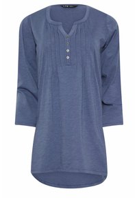 Sininen pitkähihaine tunika, jossa on pyöreä pääntie, nappilista ja pleattilyöntejä. Pehmeä, kevyt kangas ja kaareva helma.