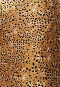 Tessuto con stampa animalier che presenta uno sfondo dorato con macchie nere e bianche. La texture sembra liscia e leggera con una leggera lucentezza.
