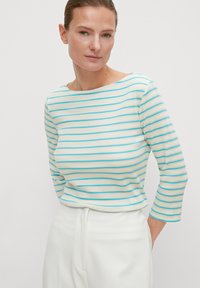 Gestreiftes Oberteil mit 3/4-Ärmeln, aus geripptem Stoff in Weiß mit blauen und beigen Streifen. Bootsausschnitt und figurnahe Silhouette.