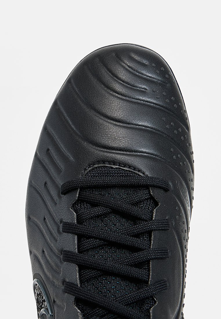 Schwarzer Fußballschuh mit strukturiertem, synthetischem Obermaterial, das durch geschwungene Linien und ausgeprägte Nähte besticht, sowie einer schwarzen Schnürung. Rundes Logo an der Seite.