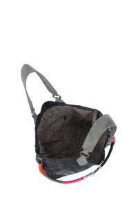 Borsa di tessuto grigio con una superficie texture, dotata di un interno a pois, spallacci grigi regolabili e dettagli colorati sul manico.