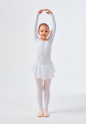 Weißes Langarm-Modell mit V-Ausschnitt, geschichteter Rock, kombiniert mit weißen Strumpfhosen und rosa Ballettschuhen. Haare ordentlich zurückgebunden.