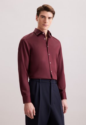 Bordeaux fitted skjorte i glat stof med lange ærmer, button-down krave og hvide knapper, parret med marineblå skræddersyede bukser.