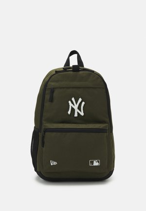 Zaino verde oliva con accentazioni nere, logo ricamato, tasca frontale con zip e tasca laterale in rete. Realizzato in tessuto resistente. Spallacci regolabili.