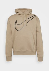 Sudadera con capucha beige con un gran swoosh negro de Nike y el pequeño texto "Just do it." Bolsillo frontal y cordones.