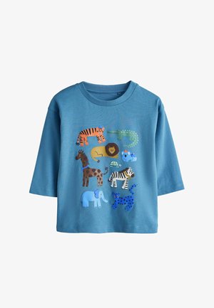 Tricou din bumbac albastru deschis cu guler rotund; prezintă ilustrații colorate cu animale, inclusiv tigru, leu, elefant și zebră.