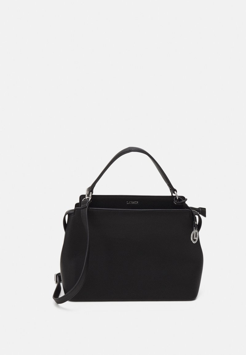Sac à main en cuir noir avec une poignée supérieure, une bandoulière détachable et un charm logo circulaire argenté sur un fond uni.
