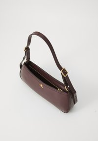 Bolso de mano de cuero burdeos con un diseño estructurado, correa ajustable, acentos de hardware en dorado y cierre superior con cremallera. Presenta detalles del logotipo.