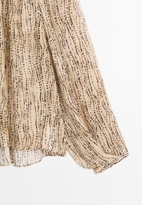 Leichtes, durchscheinendes Kleid in Beige mit braunem Punktmuster. Verfügt über ein fließendes Design und einen geschichteten Saum. Weiche Textur, lässige Silhouette.