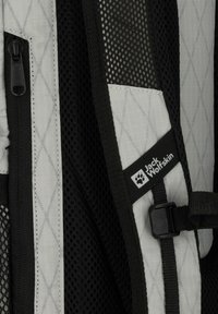 Zaino grigio e nero con tessuto a motivo a rombi, dettagli in rete, una cerniera e un'etichetta con il logo di Jack Wolfskin.