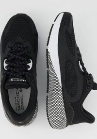 Scarpe sportive nere con parte superiore in mesh, suola in gomma bianca, colletto imbottito e accenti a motivo bianco e nero contrastante sui lati.