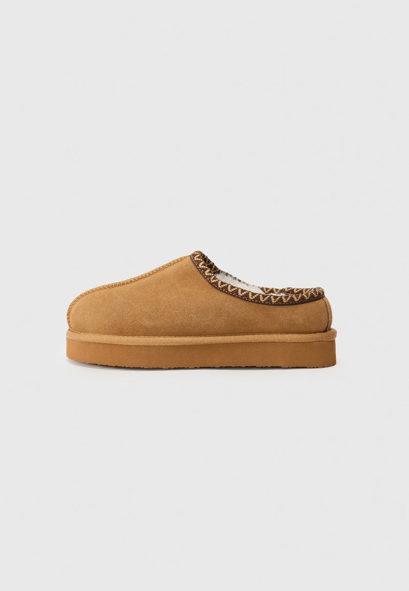 Kergedest nahast slip-on jalanõud, millel on ümar nina, tekstuuriga õmblus ja paks, pruun kummitald. Kaunistavad kudumise aktsendid avamisel.