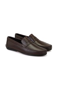 Donkerbruine leren instappers met een gladde afwerking, voorzien van decoratieve stiksels langs de teen en een platte rubberen zool.