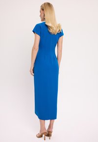 Niebieska, dopasowana sukienka z krótkimi rękawami, o długości do kolan i gładkiej fakturze. Posiada zamek błyskawiczny z tyłu oraz delikatne detale szwów.