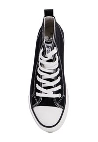 Zwarte hoge sneaker van canvas, met witte veters, een witte rubberen neuskap en contrasterende stiksels. Maatlabel zichtbaar aan de binnenkant.