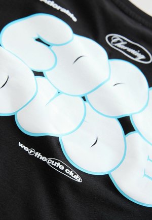Schwarzes T-Shirt mit großen weißen und hellblauen Blasenbuchstaben, mit dem Text "wir sind der süße Club" in kleinerer Schrift am unteren Rand.