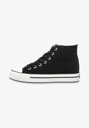 Baskets montantes en toile noire avec capuchon en caoutchouc blanc et semelle blanche, dotées de six œillets en métal et de lacets noirs, ornées d'un accent de logo bleu.