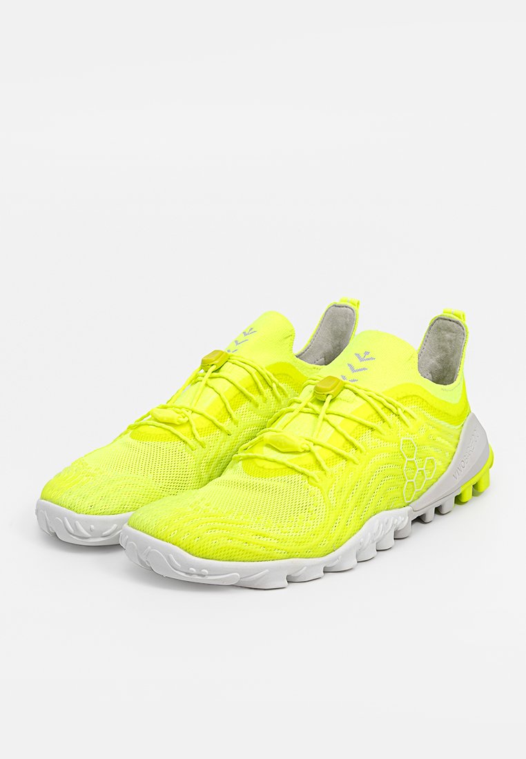 Zapatillas deportivas de color amarillo brillante con parte superior de malla, diseño curvado y suela de goma blanca. Cuentan con cordones y acentos texturizados para un mejor agarre.
