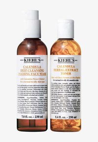 Kiehl's Kwiatowy Żel do Mycia Twarzy z Nagietkiem i Tonik w przezroczystych butelkach z pompką i zakrętką typu flip-top, ukazujące bursztynową ciecz i ekstrakty kwiatowe.