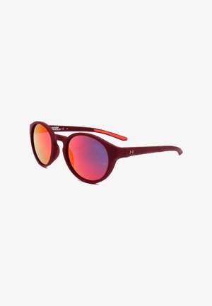 Occhiali da sole con montatura rotonda, aste rosse opache e lenti riflettenti arancioni-rosa inclinati su sfondo bianco.