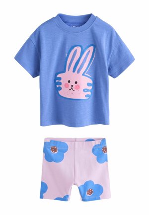 Blaues Kurzarmhemd mit rosa Hasengesicht und hellrosa Shorts, verziert mit großen blauen Blumen und braunen Zentren.
