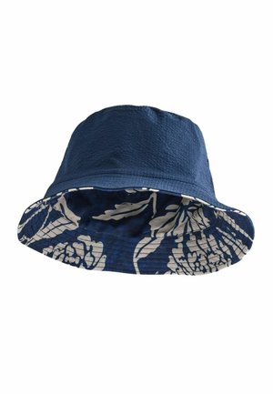 Odwracalny granatowy kapelusz typu bucket z teksturowaną tkaniną na górze i białym kwiatowym wzorem na spodniej stronie ronda.