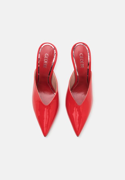 Red patent leather slingback heels with a pointed toe and smooth texture. Features a low-cut vamp and a minimalistic design.