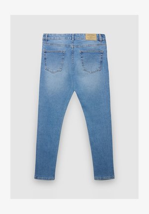 Jeans in denim azzurro chiaro con una vestibilità aderente, dotati di due tasche posteriori e di un'etichetta in pelle con marchio sulla vita.