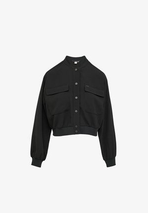 Veste noire courte avec col montant, fermeture à boutons sur le devant, deux poches poitrine et poignets et ourlet élastiqués. Texture de tissu lisse.