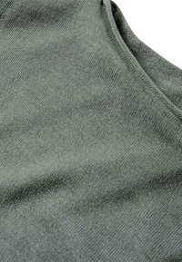 Texture de tissu en coton gris avec une finition lisse. La surface présente un motif de tricot subtil, mettant en avant une encolure dégagée.