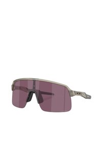 Occhiali da sole sportivi con montatura trasparente e lenti color porpora. Presentano un arco sopracciliare e aste laterali prominenti per una maggiore stabilità.