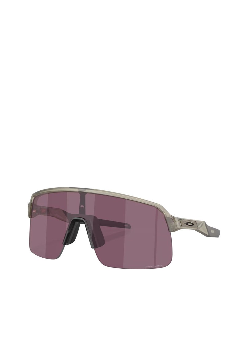 Occhiali da sole sportivi con montatura trasparente e lenti color porpora. Presentano un arco sopracciliare e aste laterali prominenti per una maggiore stabilità.