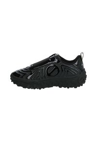 Sneaker nera slip-on con superficie lucida, modelli a onda testurizzati e suola in gomma spessa con impugnature circolari. Design minimalista.