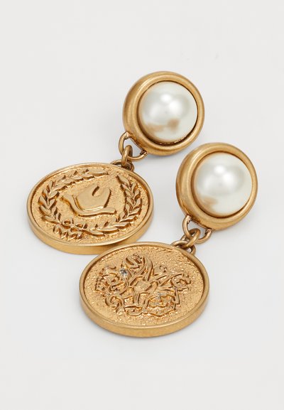 Boucles d'oreilles dorées ornées de deux pendentifs ronds, l'un avec un motif floral et l'autre avec un oiseau. Agrémentées de fausses perles blanches.