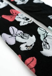 Calze nere con un motivo di volti di personaggi dei cartoni animati con fiocchi colorati in rosa, lavanda e blu. Tessuto morbido a maglia con una finitura strutturata.